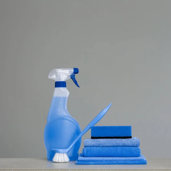 清洁蓝色喷雾瓶与塑料分配器 擦洗刷子为菜和布为灰色背景的灰尘 清洁工具 复制空间 — 图库照片