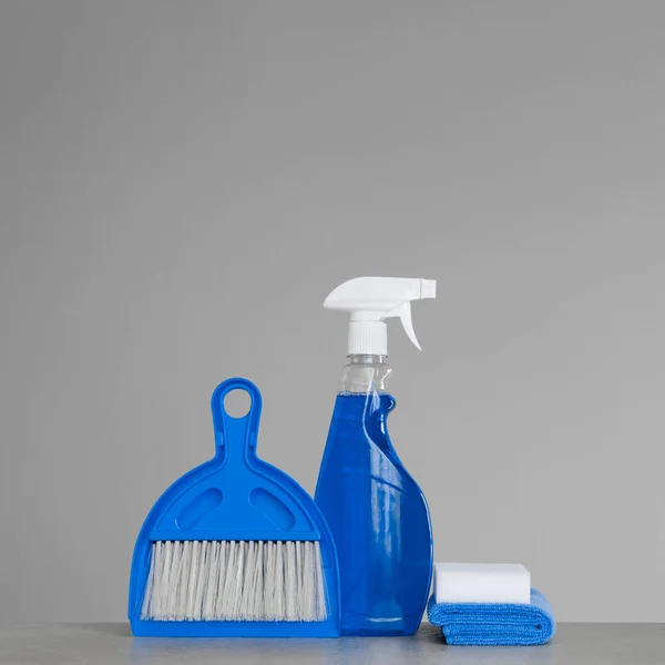中性背景上的蓝色清洁套件 喷雾洗涤剂 防尘布 勺子和扫帚 复制空间 — 图库照片
