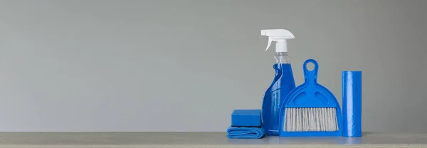 蓝色清洁设置在中性背景 喷雾洗涤剂 垃圾袋 防尘布 勺子和扫帚 复制空间 — 图库照片