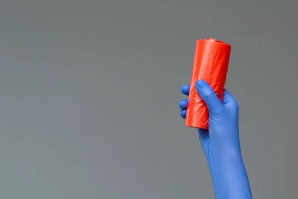 Hand Rubber Glove Holds Colored Garbage Bag Neutral Background Concept — Stock Photo, Image