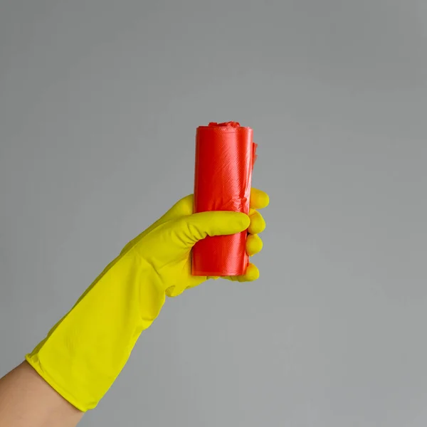 Hand Rubber Glove Holds Colored Garbage Bag Neutral Background Concept — Stock Photo, Image