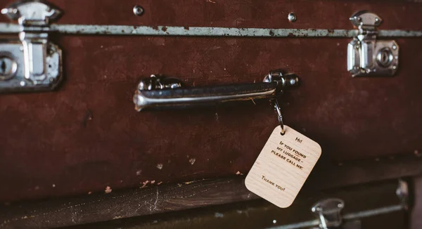 Wooden Luggage tag with the inscription on the handle of a vintage suitcase