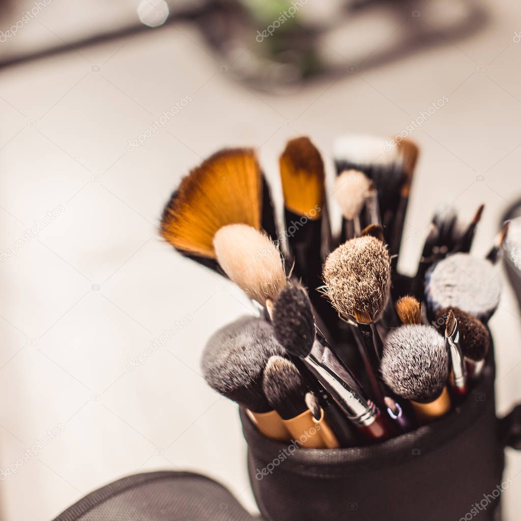 Makeup artist tools-makeup brushes on the table with a mirror.