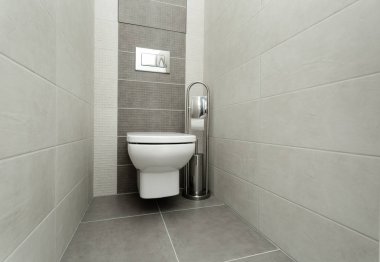 Kağıt tutucu ve tuvalet fırçası ile modern banyo beyaz klozet.