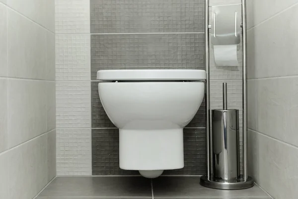 Kağıt tutucu ve tuvalet fırçası ile modern banyo beyaz klozet.