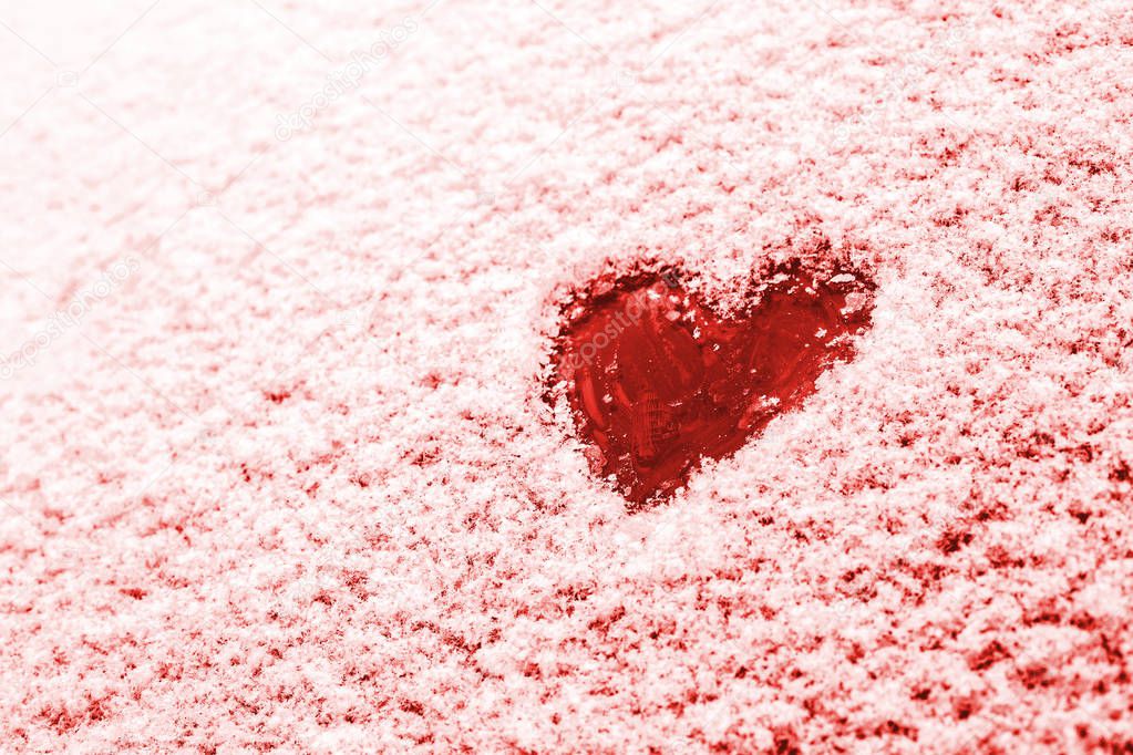 Heart painted on the snow-covered windshield of a car. Copy space. 