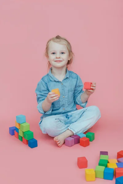 Charming Little Girl Denim Clothes Pink Background Plays Wooden Colored — Stock Photo, Image