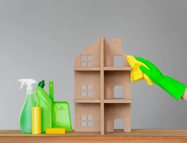 一名妇女戴着橡胶手套的手用一块绿布清洗房子旁边的象征性房子 一套五颜六色的清洁工具 春季清洁和清洁的概念 — 图库照片