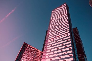 Modern yüksek yükselen gökdelen yukarı doğru mavi gökyüzü - mimari detay arka planda mavi ve yaşam mercan renkler aracılığıyla görüntülemek.