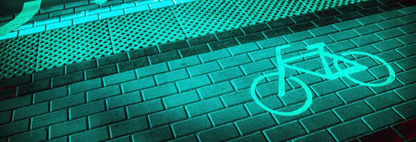 Символ велосипедной дорожки на черепичной дорожке рядом с плиткой для слабовидящих. Тонированные
.
