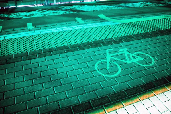 視覚障害者のためのタイルの横にあるタイル張りの道に自転車パスの記号です — ストック写真