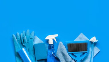 Evde bahar temizliği için mavi set-paçaları, temizlik maddesi bir şişe, kauçuk eldiven, süngerler, fırçalar ve bir süpürge ile bir kepçe. Üst görünüm. Metin için Yerleştir.