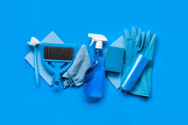 Blue set for spring cleaning in the house - rags, a bottle of cleaning agent, rubber gloves, sponges, brushes and a scoop with a broom. Top view.