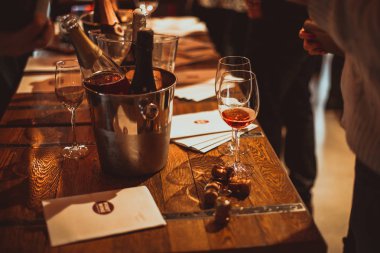 Moskova, Rusya-30 Mart 2019: şarap tadımı: bir kadeh gül şarabı, şarapların soğutuldğu broşürler, şampanya mantarları ve gümüş kovaların yanında tadım masasında duruyor.