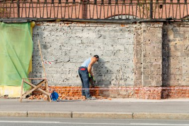 St. Petersburg, Rusya-16 Ağustos 2018: işçi binanın etrafındaki tuğla çitleri onarıyor
