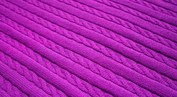 Texture of knitted dark purple fabric. Violet knitted abstract background.