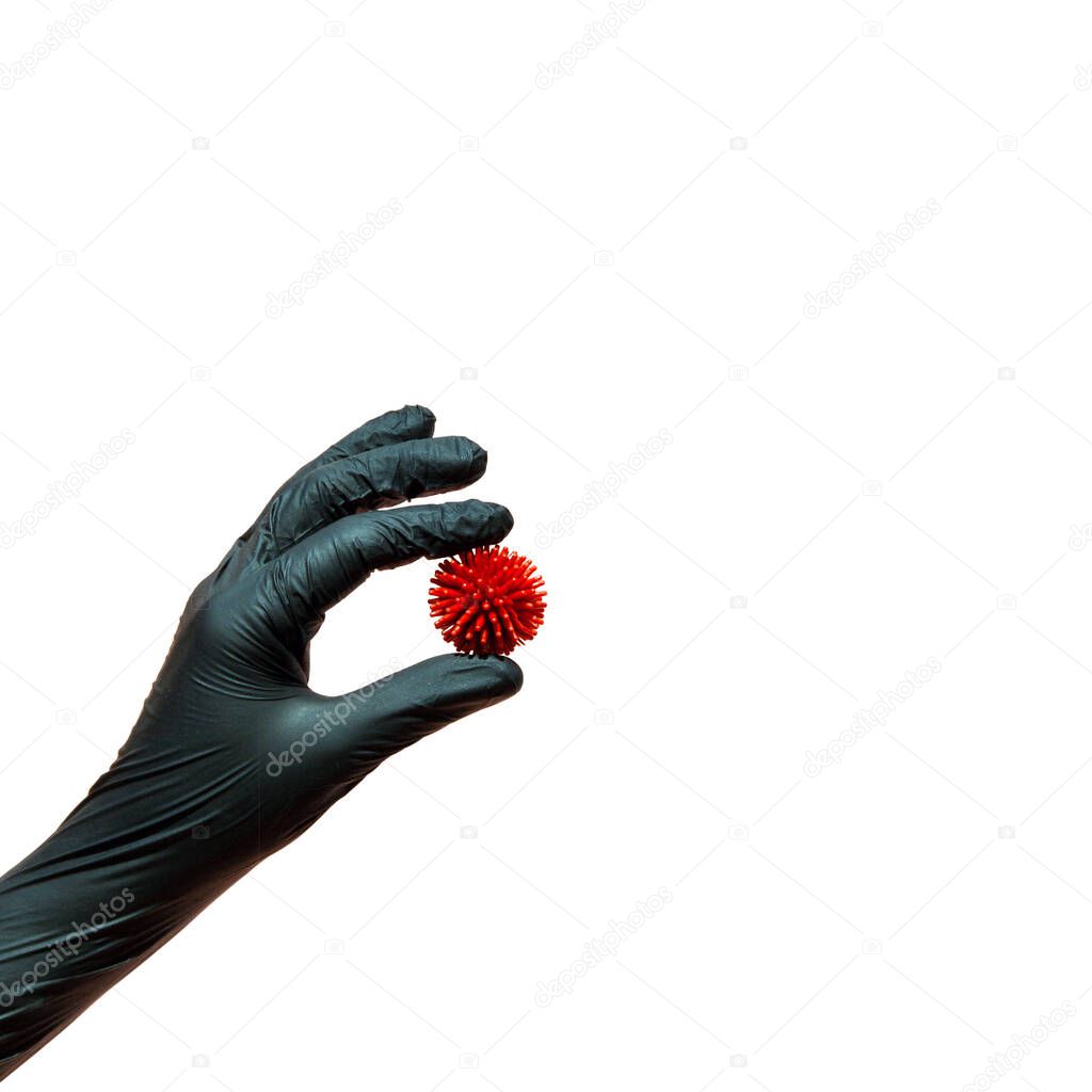 A hand in a protective black glove holds a model of the covid-19 virus . Isolated on a white. The concept of protection against coronovirus, compliance with hygiene rules and preventive measures.