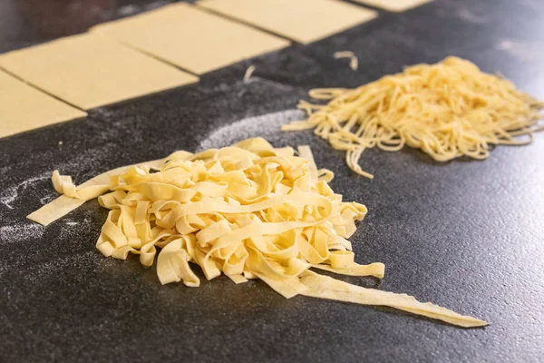 Tagliatelle ve koyu ahşap üzerinde spagetti