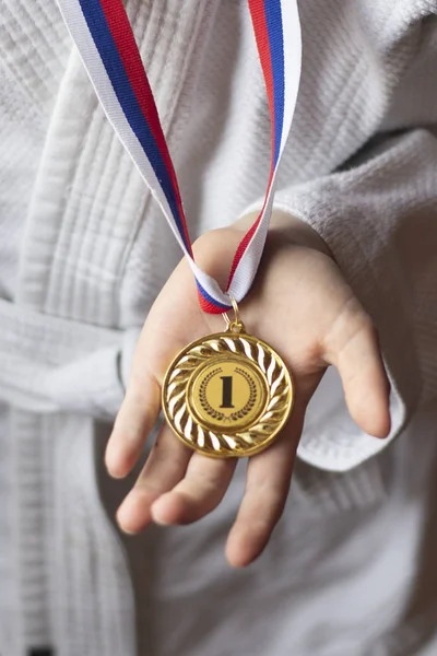 karate boy holds a medal