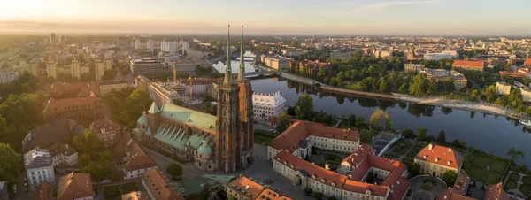 Wroclaw 'da uyanan Ostrow Tumski' nin sabah hava görüntüsü. Nehir kenarındaki tarihi şehrin güzel manzarası. Katedral binasının ikiz kuleleri diğer tarihi kent mimarisine hakim.