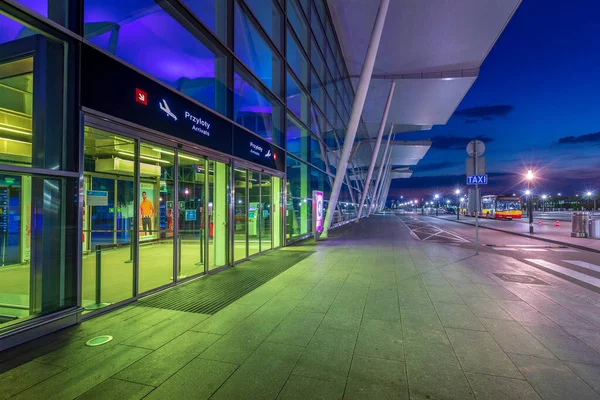 Wroclaw, Polonya - 17 Haziran 2020: Günbatımında modern Wroclaw Havalimanı 'nda (EPWR) kalkış salonuna giriş. Sokak otobüsünde yolcu bekliyor. Gece havalimanı, cam duvardaki yansımalar ve aydınlatma