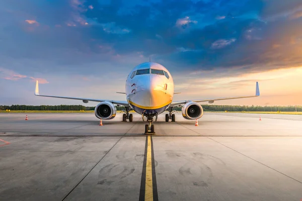 Modern commercial airplane in the parking lot of the airport apron, waiting for services maintenance, refilling fuel, and passenger boarding the plane. Concept of travel, holidays and business jet