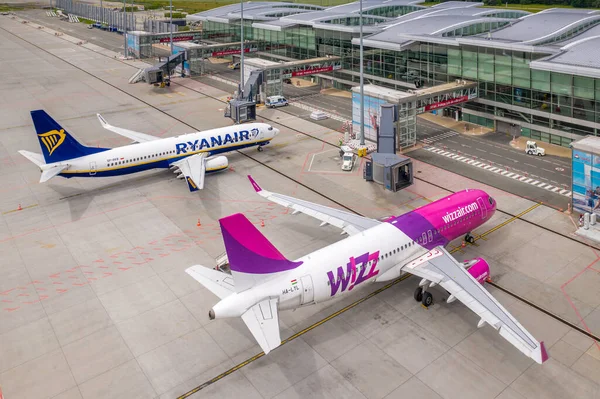 Wroclaw, Polonya - 17 Haziran 2020: Airbus ve Boeing Wroclaw Havaalanı 'nın önünde bakım bekliyor. Jet köprüleri ve havaalanı ekipmanları var. İHA 'dan çekilen hava uçakları fotoğrafı.