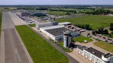 Wroclaw, Polonya - 17 Haziran 2020: Öndeki modern TWR Kulesi binası ve arkadaki modern terminalde park etmiş uçaklar. İHA atışı