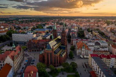 Gün batımında eski kasaba binalarının ve Aziz Peter Katedrali ve Havari Paul Katedrali 'nin hava aracı görüntüsü. Uzaktan dev dağlar görülebilir. Legnica, Polonya 'da güneş ışınlarında eski mimari