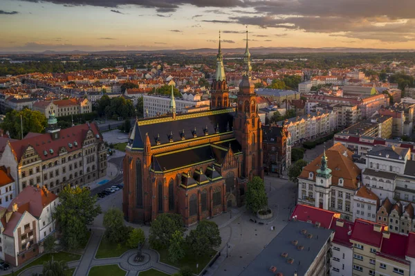 聖ペテロ大聖堂と使徒パウロと日没前の古い町の建物の空中ドローンビュー 太陽の光はポーランドのレグニツァの都市建築を美しく強調しています — ストック写真