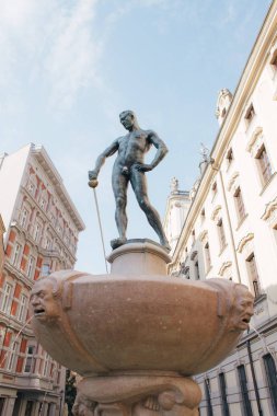 Avrupa'nın güzel binaların zemin üzerine bir kılıçla çıplak bir adam heykeli