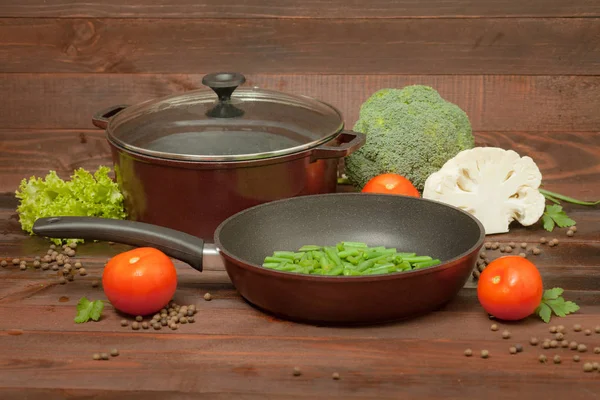 Alüminyum non-sopa cookware ahşap zemin üzerine sebzeli