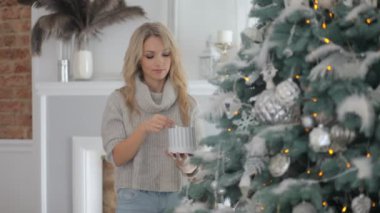 Güzel bir kız büyük bir Noel ağacı süsle
