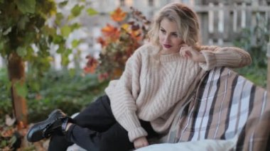 Bir fotoğraf çekimi üzerinde bej kazaklı sarışın kız