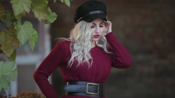 Blond meisje in een rode trui op een fotoshoot — Stockvideo