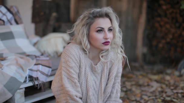Блондинка в бежевом свитере на фотосессии — стоковое видео
