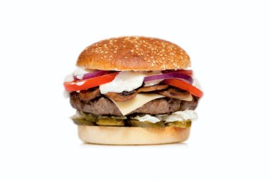 Beyaz bir arka plan büyük bir pirzola, peyniri, salatalık, domates, soğan, lahana, sos ve susam çörek ile sulu hamburger