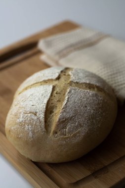 Bir somun ev yapımı mayalı hamur mayalı ekmek bulvarı. Tahtada çapraz çizim tekniği var. Karanlık ve karamsar.