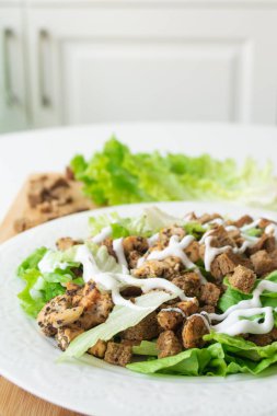 Tavuk, kızarmış ekmek, marul, parmesan peyniri ve sos yerine mantarlı klasik Sezar salatasının vejetaryen versiyonu.