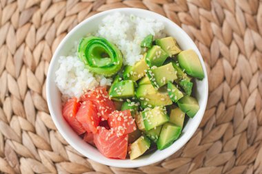 Füme somon balığı, avokado, beyaz pirinç, salatalık ve susam tohumlu Hawaii poke kasesi. Parlak ve havadar hissediyorum 