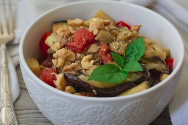 Taze domatesli ızgara patlıcan salatası, ceviz ve fesleğenle süslenmiş salata. Arka planda klasik çatal 