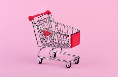 Pembe arka planda boş alışveriş arabası