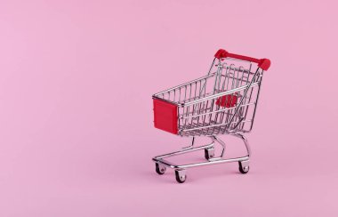 Pembe arka planda boş alışveriş arabası