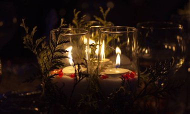 Dalları ve karanlık çevrili bir cam bir mum alevi yerleştirilen çok ilginç görünüyor