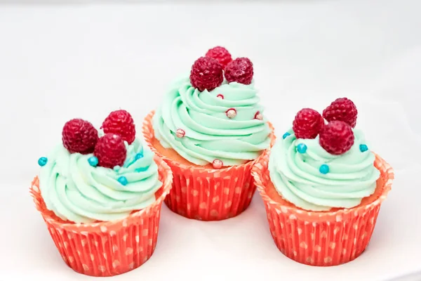 Smakelijke cupcakes met drie grote verse frambozen bovenop — Stockfoto