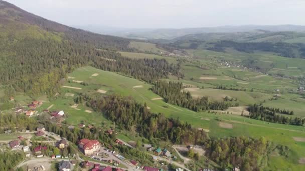 Πτήση πάνω από το δάσος στα βουνά και στο χωριό. Αεροφωτογραφία του Ουκρανικά Καρπάθια — Αρχείο Βίντεο