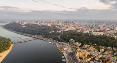 Panoramik Podol ilçe, şehir merkezi ve Vladimirskaya Gorka. Kiev Dinyeper Nehri, bir yaya köprüsü ve gün batımında geniş park alanı ile değil bankanın genel görünümü.