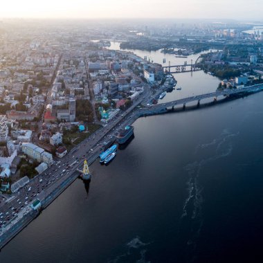Panoramik manzaralı bir nehir, bitmemiş Köprüsü ve Şehir Parkı parçası ile modern bir şehir