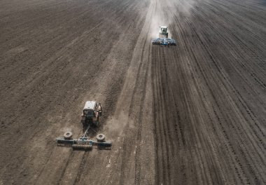 İki parlak mavi traktör kara toprağı çerçevede bir yere çiftçilik.