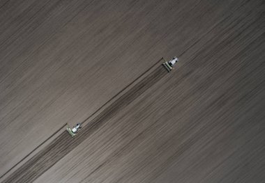 İki parlak mavi Traktörler siyah bir yere çiftçilik arka plan dünya. Üstten görünüm